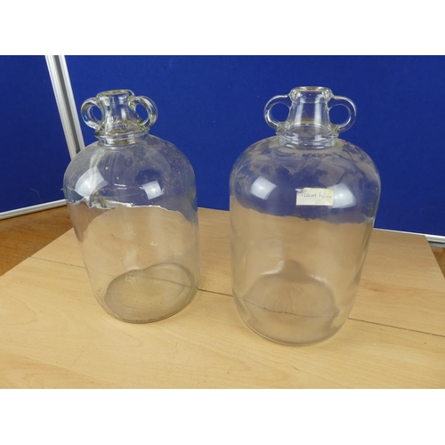 616 - Two clear glass demijohn bottles.