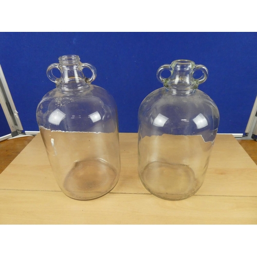 618 - Two clear glass demijohn bottles.