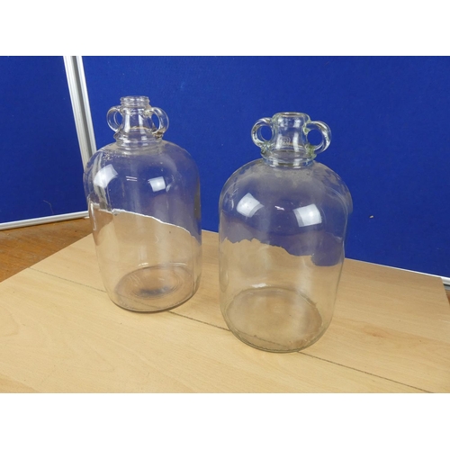 618 - Two clear glass demijohn bottles.