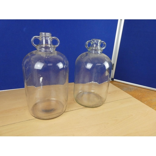 618 - Two clear glass demijohn bottles.