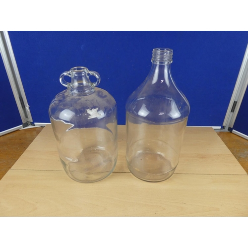 619 - A clear glass demijohn bottle and another.