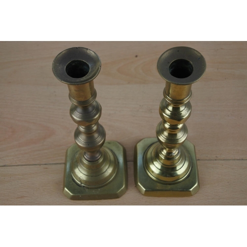 242 - A pair of brass candlesticks.