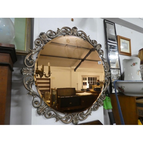 128 - A stunning tinted glass mirror, measuring 76cm in diameter.