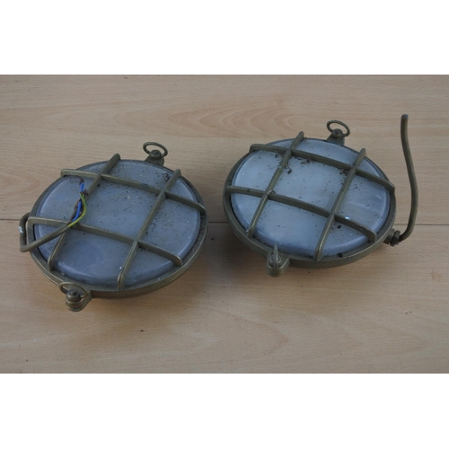 518 - Two vintage brass cased nautical lights, each measuring 15cm in diameter.