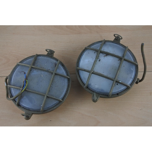 518 - Two vintage brass cased nautical lights, each measuring 15cm in diameter.