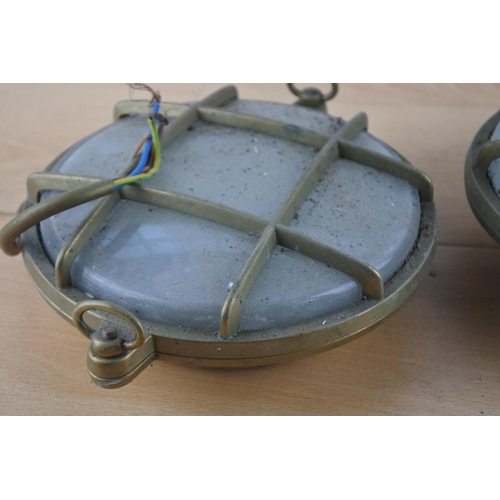 518 - Two vintage brass cased nautical lights, each measuring 15cm in diameter.