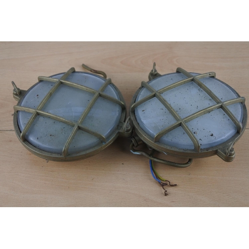 524 - Two vintage brass cased nautical lights, each measuring 15cm in diameter.