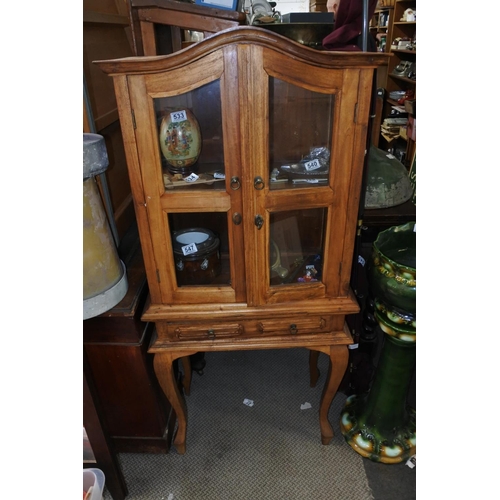 532 - A pine small two door display cabinet with drawer, measuring 60cm x 135cm x 30cm.