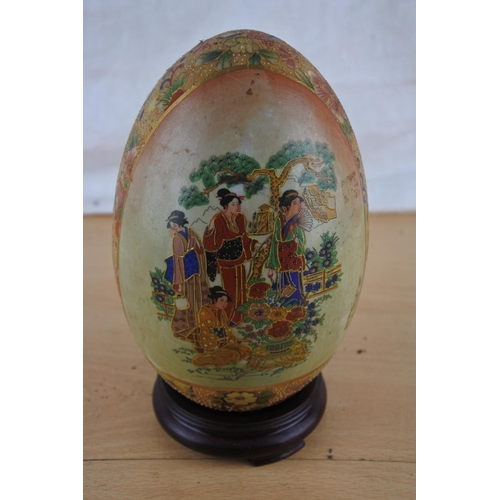 533 - An oriental patterned ceramic egg on stand.