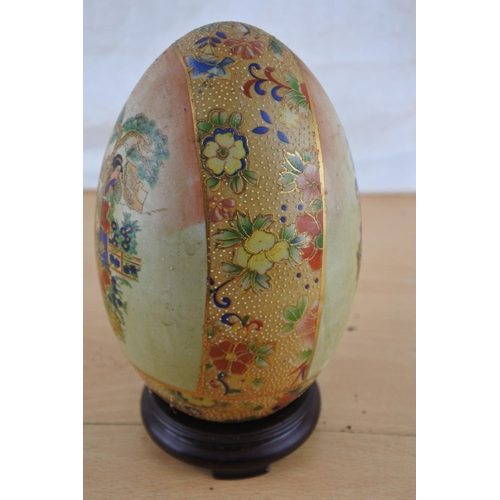 533 - An oriental patterned ceramic egg on stand.