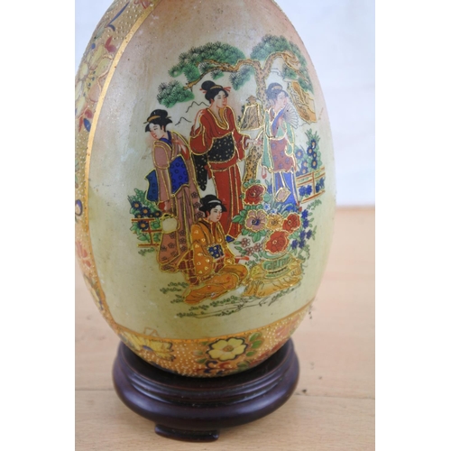 533 - An oriental patterned ceramic egg on stand.