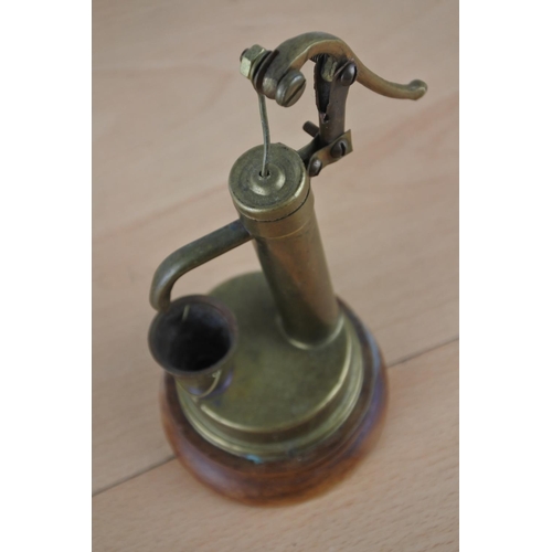 40 - An ornamental brass water pump on a wooden plinth.
