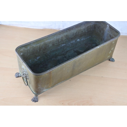 57 - A brass trough planter with lion mask handles. Approx 15x39cm.