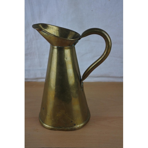 65 - A brass flagon stamped to base. Approx 21cm.