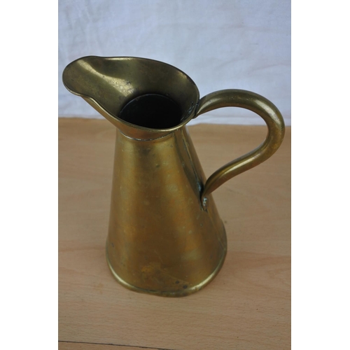 65 - A brass flagon stamped to base. Approx 21cm.