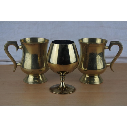 7 - Two brass engraved tankards and a brass goblet.