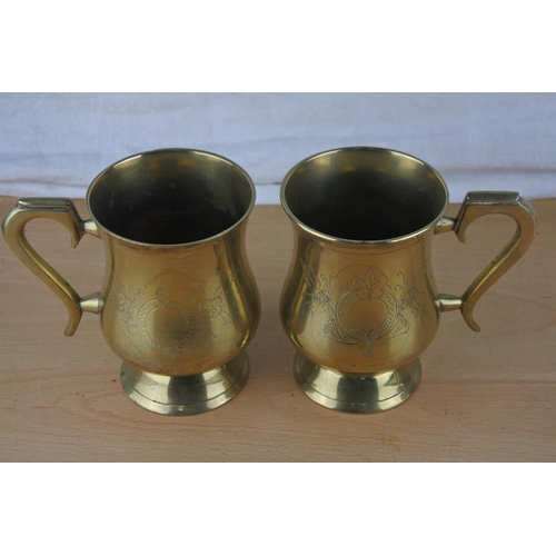 7 - Two brass engraved tankards and a brass goblet.