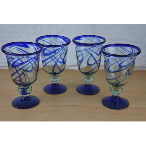 70 - Four large blue glass stripped goblets.