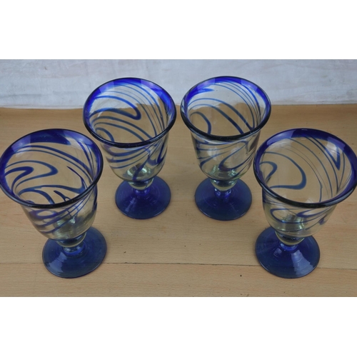 70 - Four large blue glass stripped goblets.