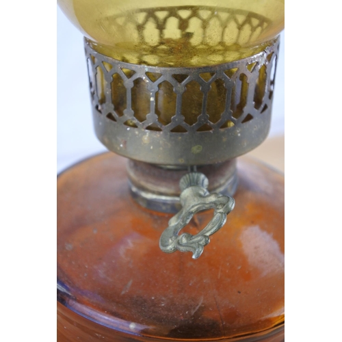 220 - A vintage amber glass oil lamp and shade.