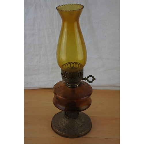 220 - A vintage amber glass oil lamp and shade.