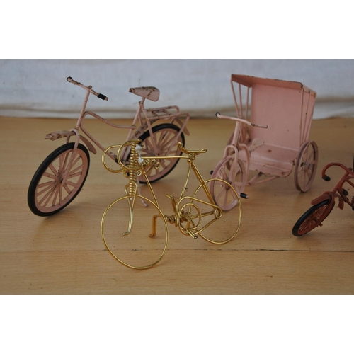 237 - A collection of miniature bicycles and a bird cage.