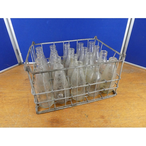 326 - A vintage metal milk bottle crate containing a lot of vintage glass milk bottles to include Leckpatr... 