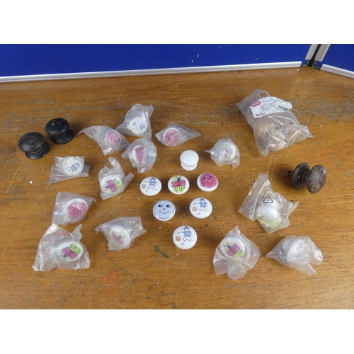 521 - A bag of assorted enamel character furniture knobs and more.