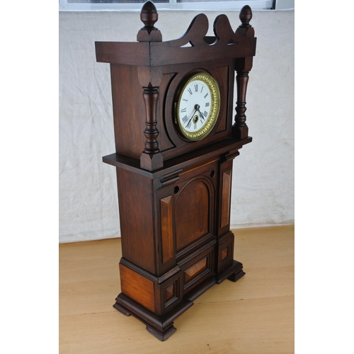 633 - An unusual mahogany cased wall clock with ceramic clock face. Approx  54cm.