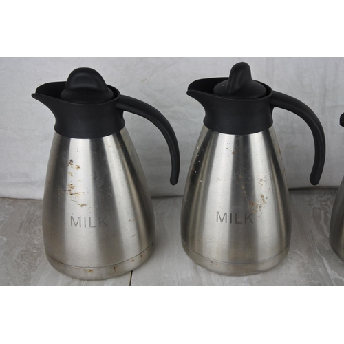 675 - Two stainless steel 'Milk' jugs and two others.
