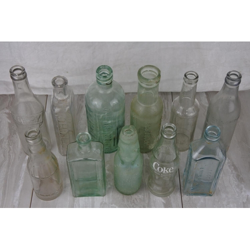 716 - A lot of antique and vintage glass bottles to include William Corry & Co, Coca Cola and more.