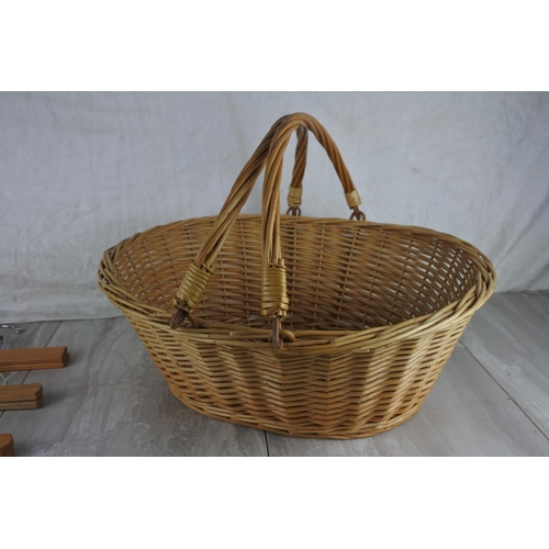 799 - A wicker two handled basket and a lot of wooden clothes hangers.