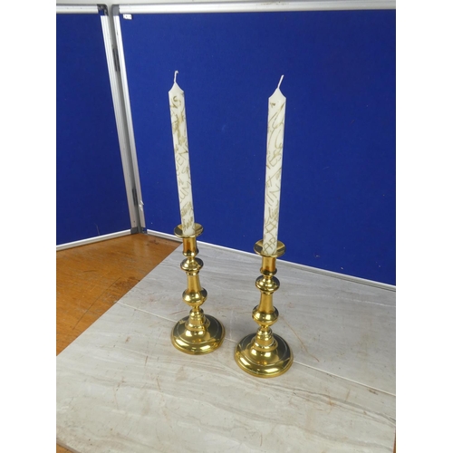 1064 - A pair of brass candlesticks with candles,