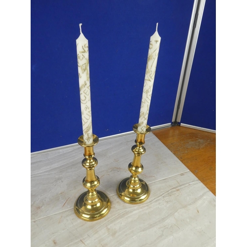 1064 - A pair of brass candlesticks with candles,