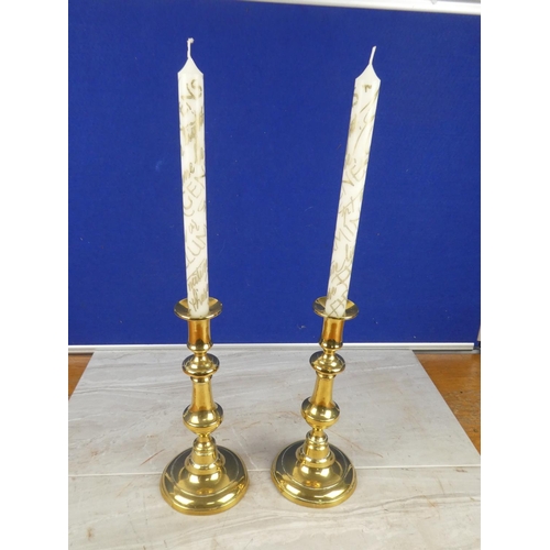 1064 - A pair of brass candlesticks with candles,