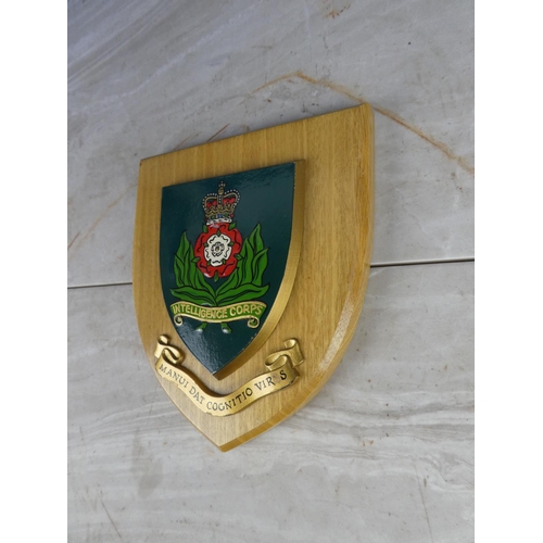 927 - A wooden shield wall plaque 'Intelligence Corps'. 18cm.