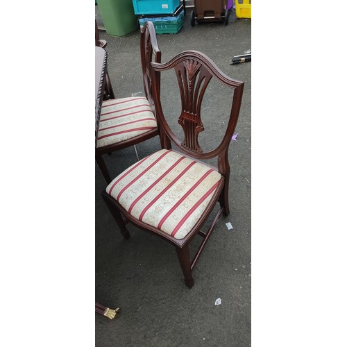 954 - A mahogany dining table and 6 matching chairs. One chair a/f.