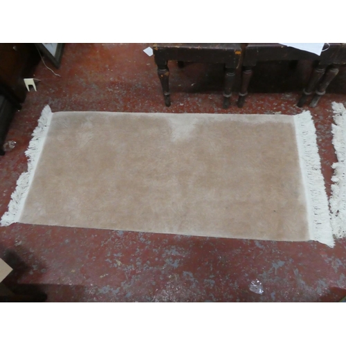 1269 - A cream patterned floor rug.