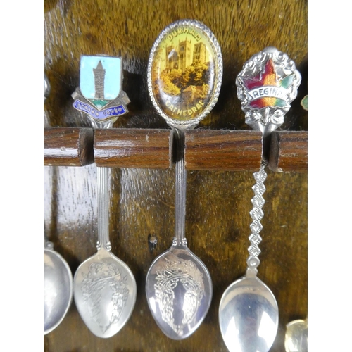 1309 - A large assortment of souvenir spoons with wall mountable display unit.