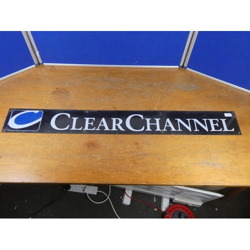 392 - A vintage 'Clear Channel' metal advertising sign. Approx 124x15cm.