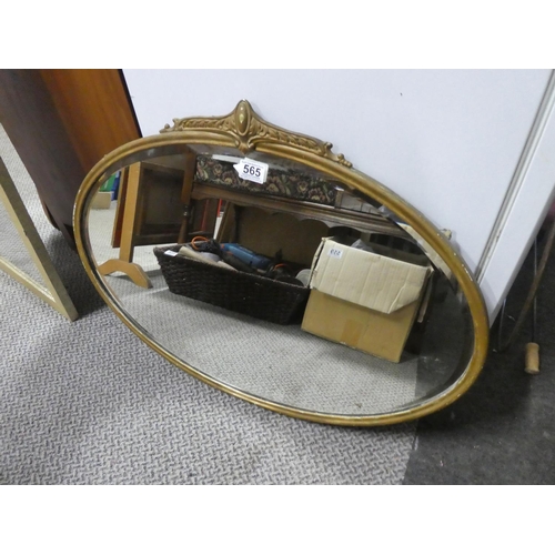565 - An antique oval wall mirror with a gilt metal frame.  Approx  50x70cm.