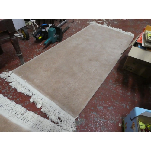 1269 - A cream patterned floor rug.