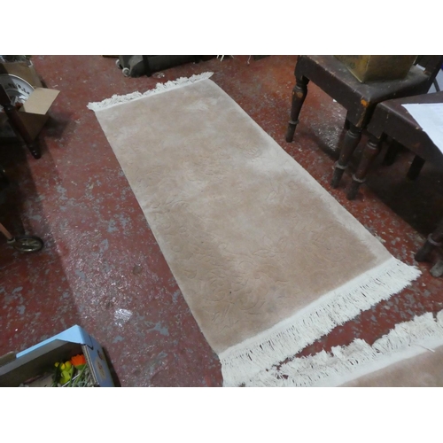 1269 - A cream patterned floor rug.