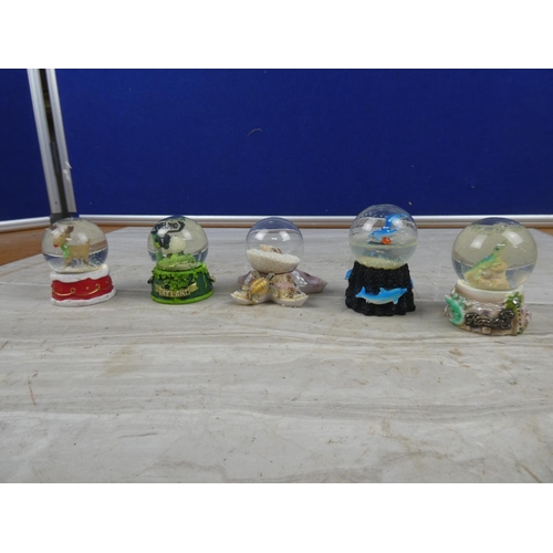 67 - Four small snow globes.