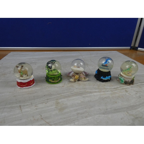 67 - Four small snow globes.