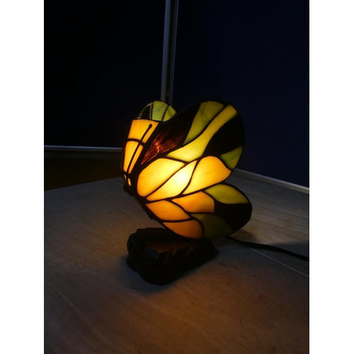 582 - A leaded glass table lamp in the style of a butterfly.