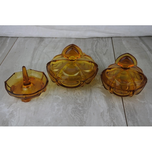 672 - A vintage three piece amber glass dressing table set.