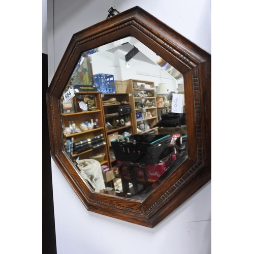 684 - An oak framed hexagonal wall mirror. Approx 52cm dia.