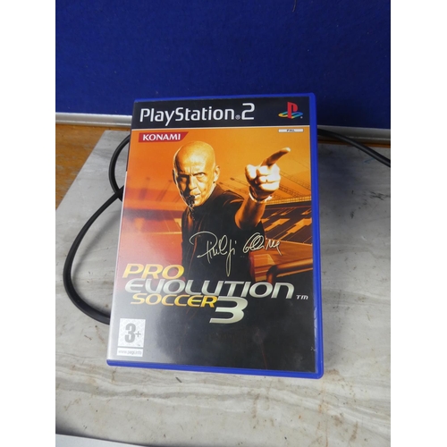 702 - A Playstation 2 console, controller, instruction manual and Pro Evolution Soccer 3 game.