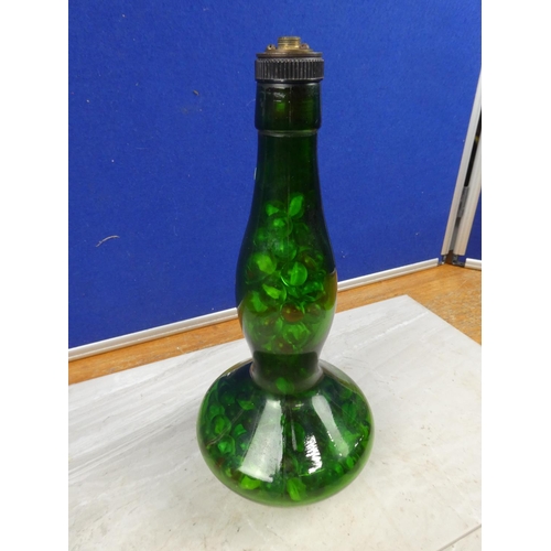 139 - A vintage green glass genie bottle containing a collection of marbles.